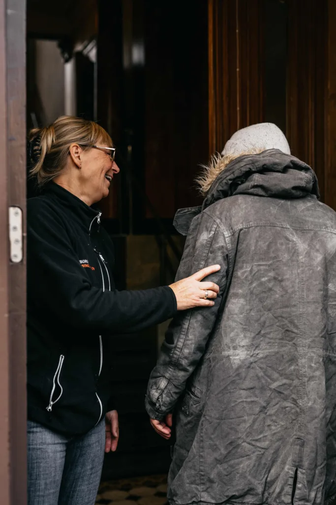 Personal välkomnar gäst på frukostcaféet med ett leende i entrén.